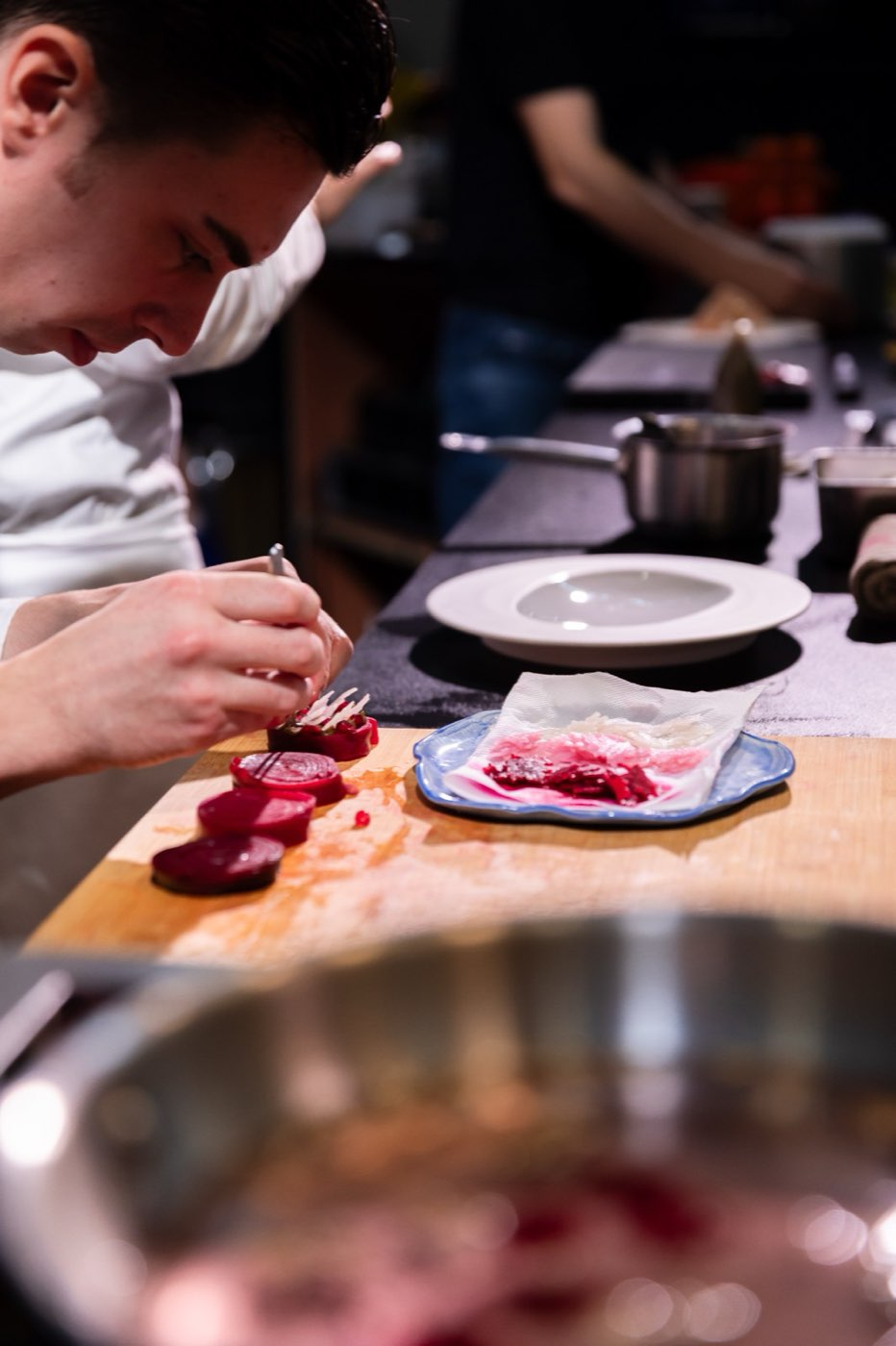 Un chef dresse une assiette en cuisine ouverte